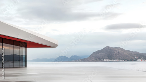 Modern architectural design overlooks a tranquil body of water with mountains in the background