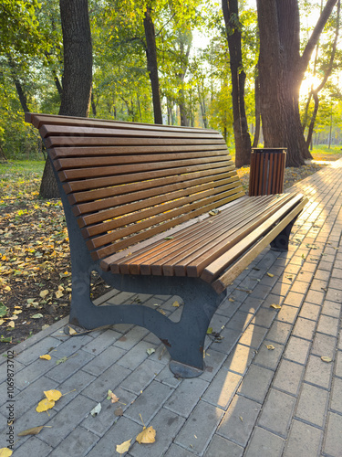 A wooden bench sits on a brick walkway in a park