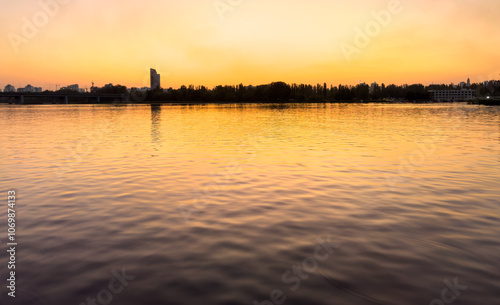 A calm body of water with a city skyline in the background