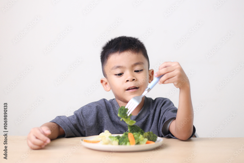 Nutrition healthy eating habits for kids concept. Children do not like to eat vegetables. Little cute boy refuses to eat healthy vegetables. Nutrition healthy eating habits for kids concept. Children do not like to eat vegetables. Little cute boy refuses to eat healthy vegetables.