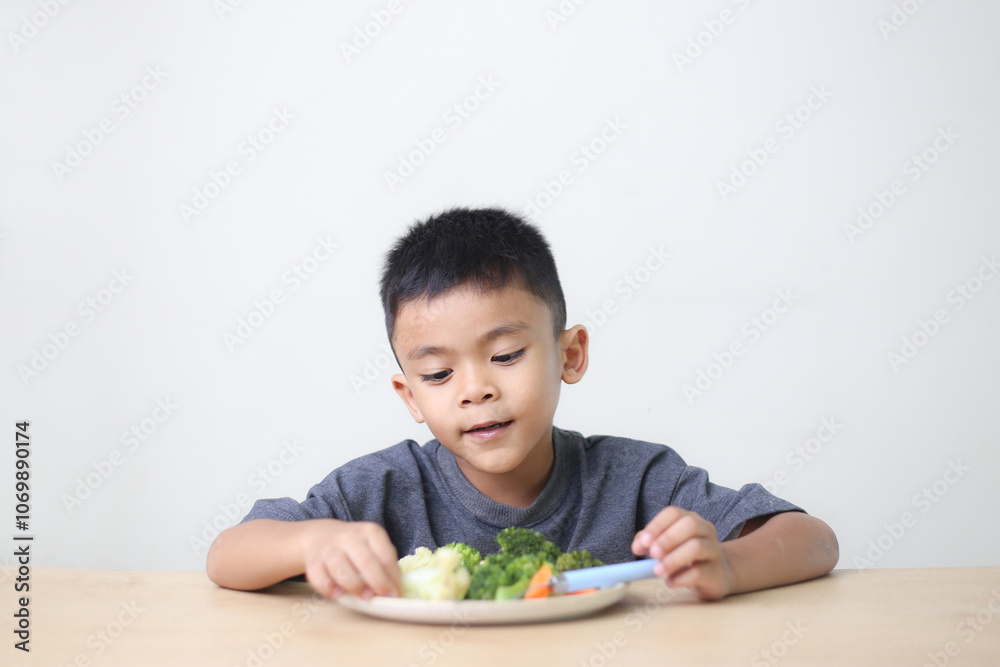 Nutrition healthy eating habits for kids concept. Children do not like to eat vegetables. Little cute boy refuses to eat healthy vegetables. Nutrition healthy eating habits for kids concept. Children do not like to eat vegetables. Little cute boy refuses to eat healthy vegetables.