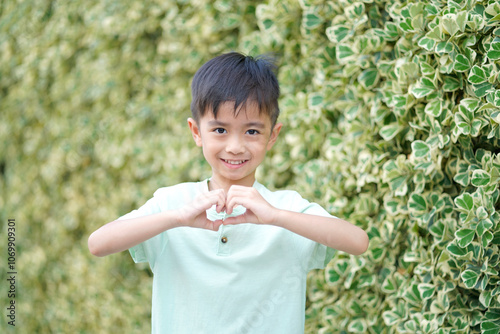 Cute boy makes a heart shape with his hands. Children have emotions of love.