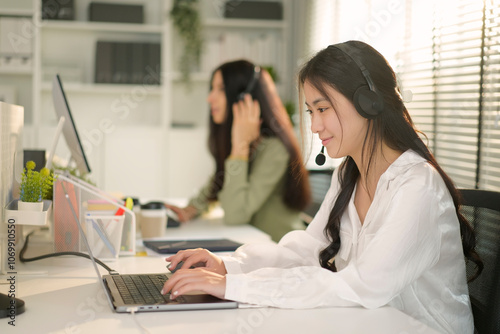 Confident young businesswoman in headphones with microphone holding video call with clients or partners, discussing project. Smiling customer support operator with hands-free headset working.