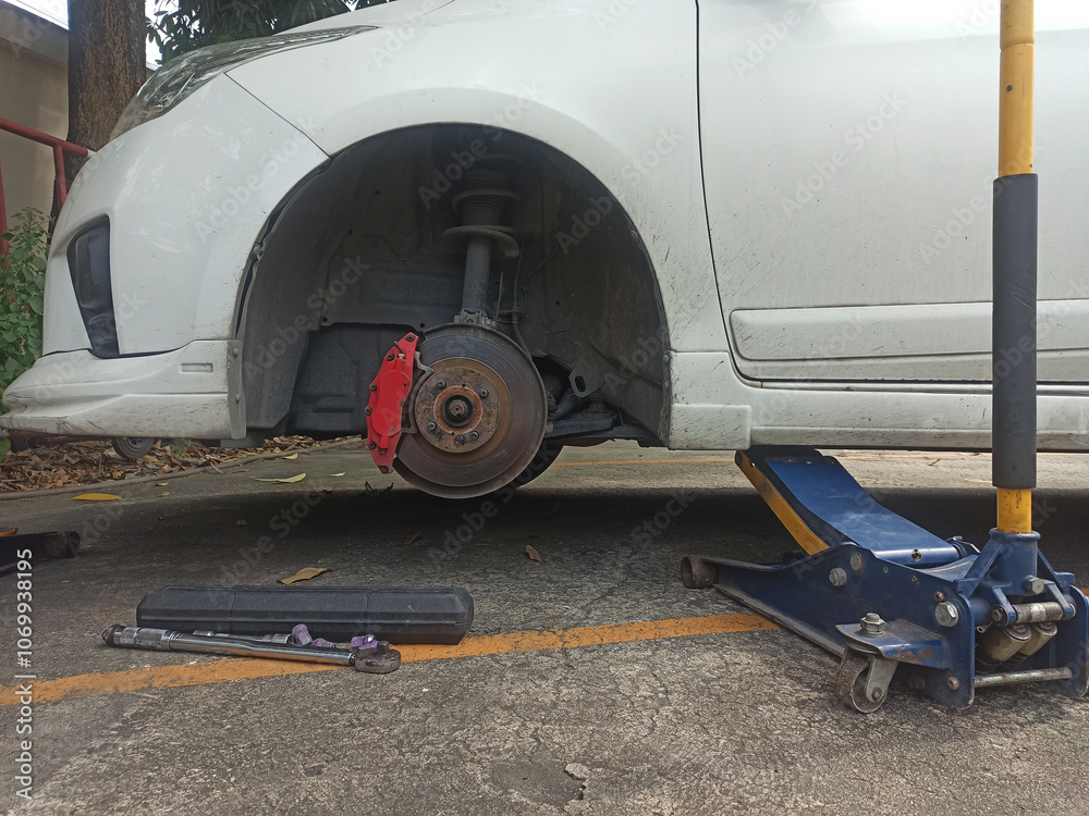 Fototapeta premium Car mechanic changing a disc brake on a car in a garage.