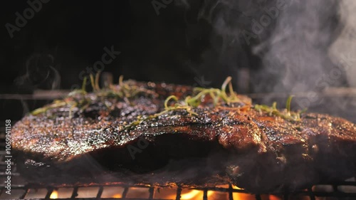 Juicy delicious piece of pork meat with rosemary is grilled. Close-up. Picnic with barbecue in nature in evening. dinner is being prepared on coals and fire. party outside with roast meat