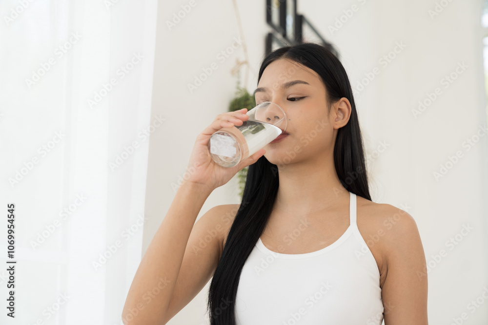 Young Asian woman drinking water in home. Health care concept Young Asian woman drinking water in home. Health care concept
