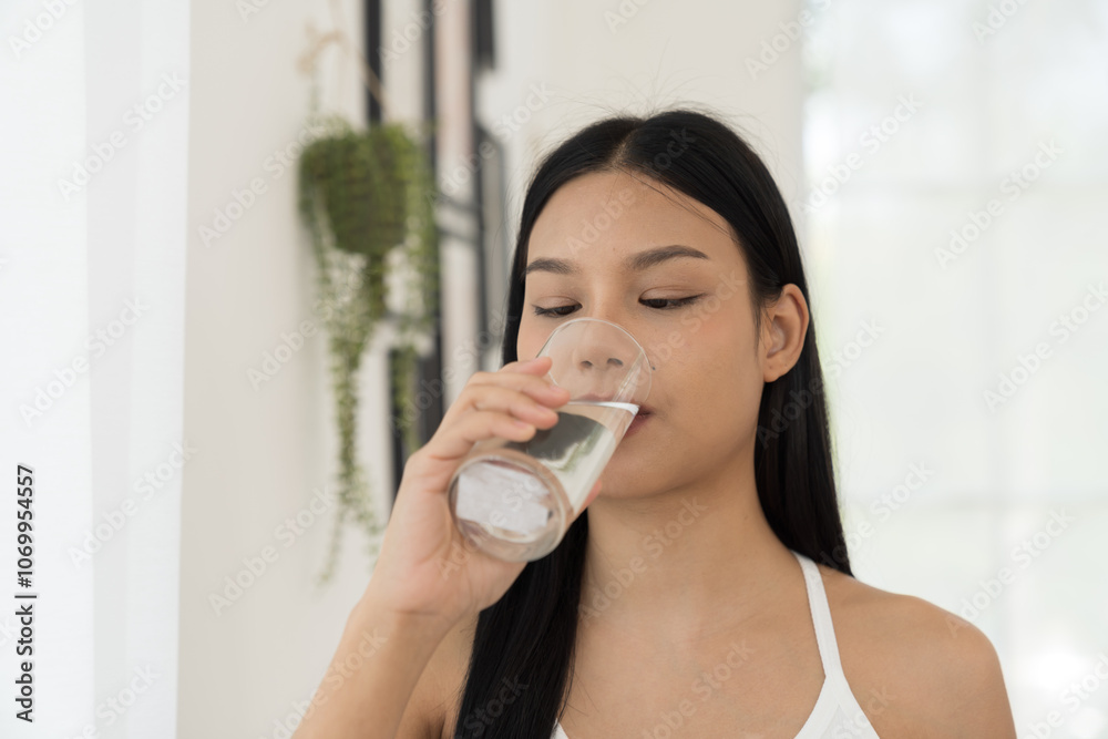 Young Asian woman drinking water in home. Health care concept Young Asian woman drinking water in home. Health care concept