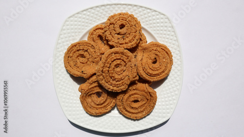 Top view of Crunchy fried homemade Chakli in a plate. Chakli is a savory snack from India made out of rice, mixed yellow and green lentils along with spices Diwali festival Indian snack called Chakli photo