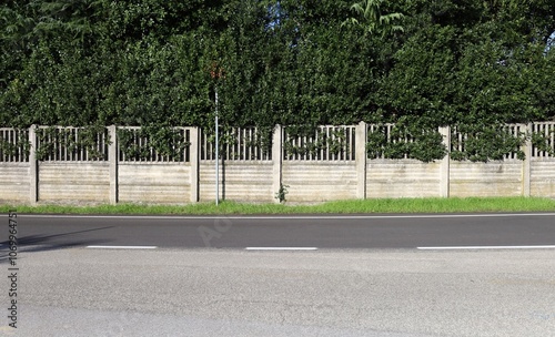 Wallpaper Mural Concrete prefab fence with horizontal bars in the bottom and railing in the upper side. High fence behind and street in front. Background for copy space.	 Torontodigital.ca