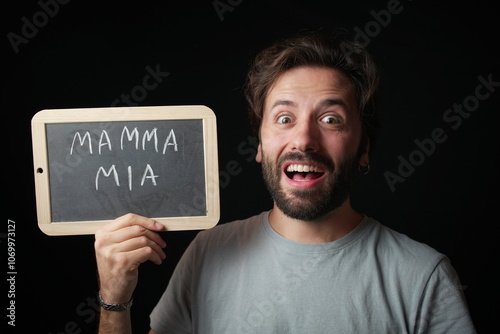 Obraz na plátně Caucasian Man holding a Chalkboard with the Handwritten word  Mamma Mia