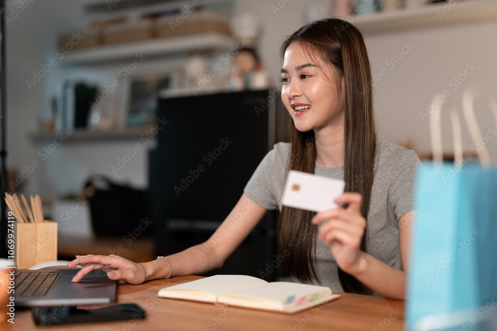 Happy young woman holding credit card using laptop paying online making purchase in e-commerce digital store on smartphone at home. Happy young woman holding credit card using laptop paying online making purchase in e-commerce digital store on smartphone at home.