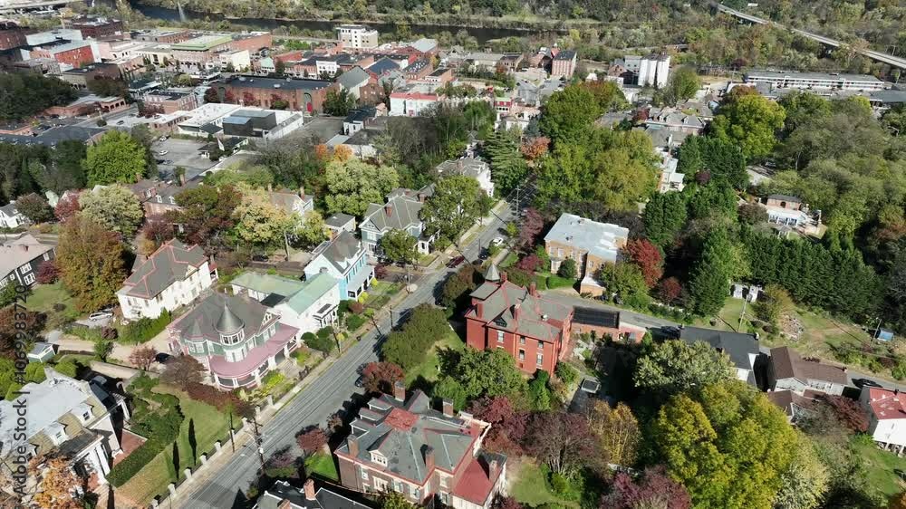 American neighborhood with american architectures design on sunny day. Beautiful autumn day in USA with Victorian and colonial types of homes. Aerial rising top down shot. American neighborhood with american architectures design on sunny day. Beautiful autumn day in USA with Victorian and colonial types of homes. Aerial rising top down shot.