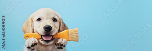 golden retriever puppy holding a yellow paintbrush against a bright blue background, perfect for themes of creativity, pets, cuteness, art, and playful moments photo