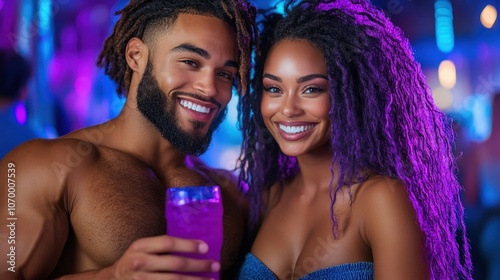 A couple smiles brightly while holding colorful drinks in their hands, enjoying each others company in a vibrant nightlife setting with colorful lighting