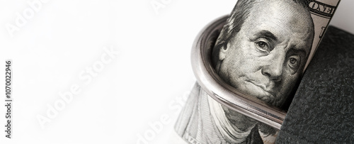 Banner, close-up of a rolled U.S. one-hundred-dollar bill with Benjamin Franklin’s face, secured within a padlock. Concept of financial security, protection, and restricted access to wealth or savings