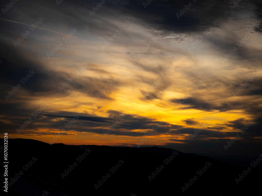 A stunning sunset over Schauinsland, with dramatic clouds and warm hues filling the sky. The vibrant colors create a mesmerizing scene as the day fades into night. A stunning sunset over Schauinsland, with dramatic clouds and warm hues filling the sky. The vibrant colors create a mesmerizing scene as the day fades into night.