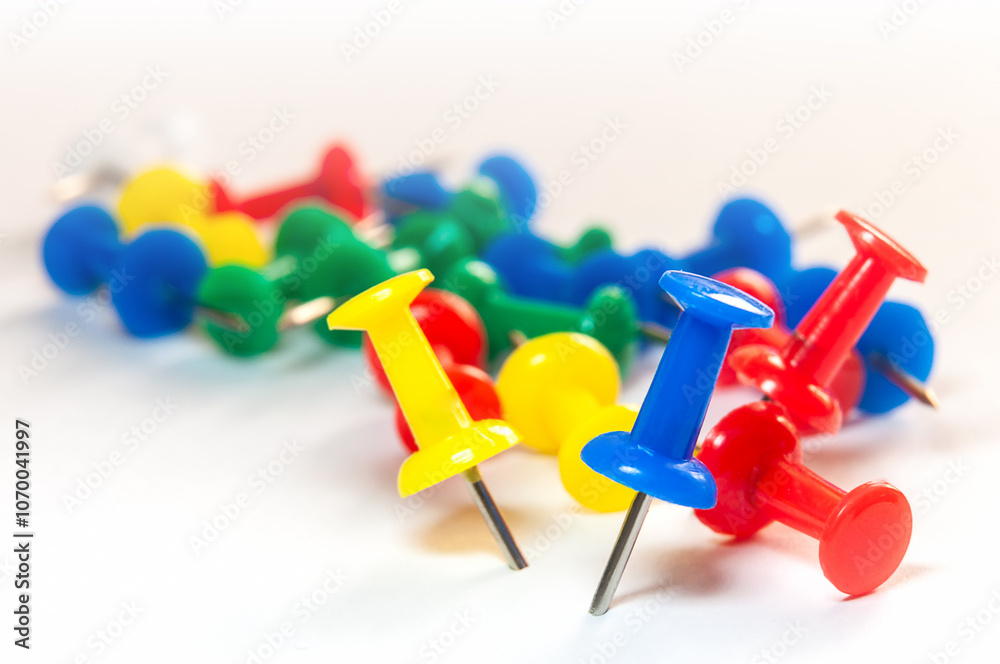 Colorful push pins scattered on white background Colorful push pins scattered on white background
