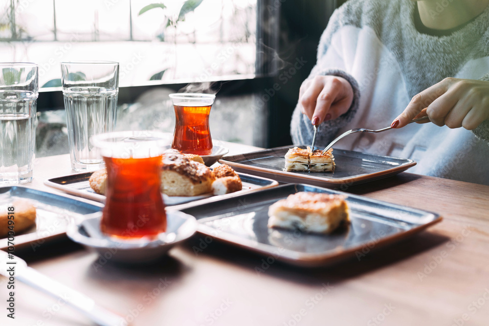 Traditional Turkish breakfast with su böreği (layered pastry with cheese filling) served alongside Turkish tea, highlighting a comforting combination of savory pastry and aromatic tea. Traditional Turkish breakfast with su böreği (layered pastry with cheese filling) served alongside Turkish tea, highlighting a comforting combination of savory pastry and aromatic tea.