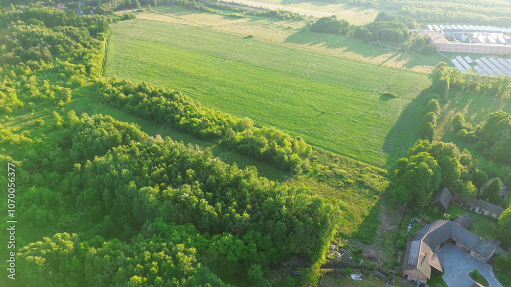 Fototapeta premium Aerial countryside with fields and trees at sunset