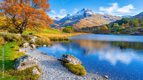 stunning image of serene mountain lake with autumn trees and snow capped peaks reflecting in water. vibrant colors and peaceful setting create breathtaking scene