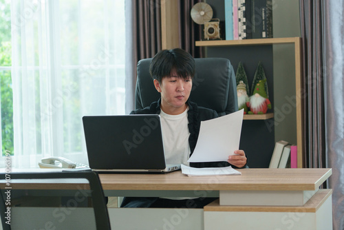 A beautiful businesswoman is sitting and looking at a computer screen, writing a plan, and planning daily appointments. photo