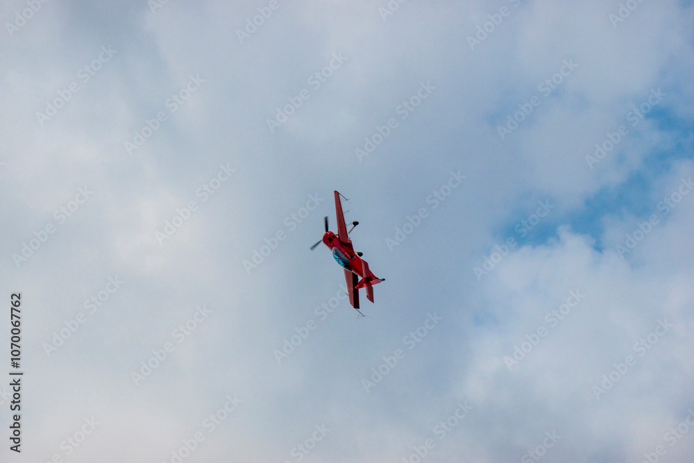 A pilot flies an aerobatic propeller plane in the sky A pilot flies an aerobatic propeller plane in the sky