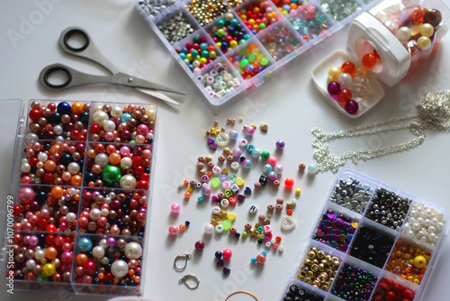 Colorful beads, letter beads, threads and other jewelry making supplies on white background. Making friendship bracelets concept. Selective focus.