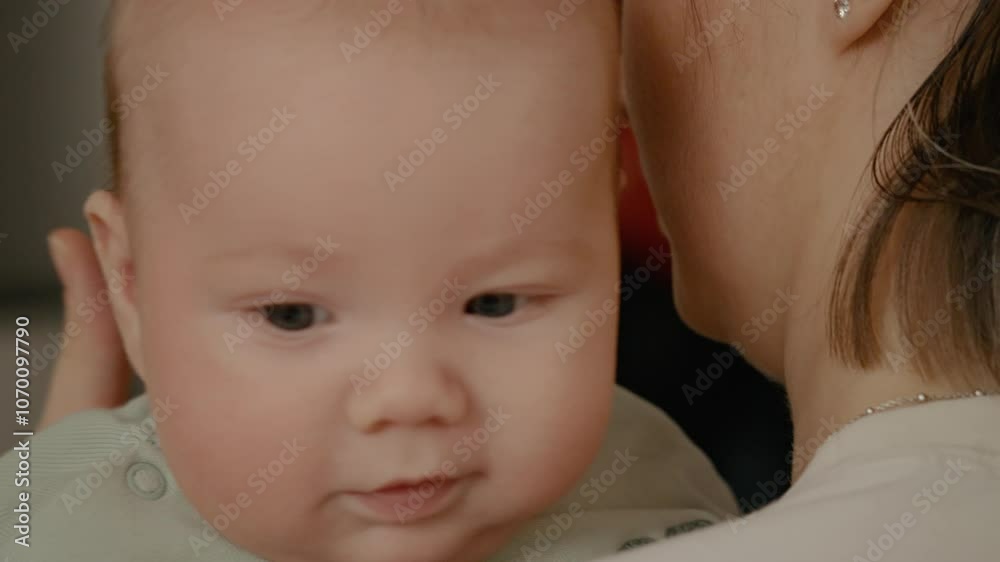 Woman mother holds and kisses baby toddler from her arms. Baby kid boy or girl, mom hugging baby. Woman mother holds and kisses baby toddler from her arms. Baby kid boy or girl, mom hugging baby.