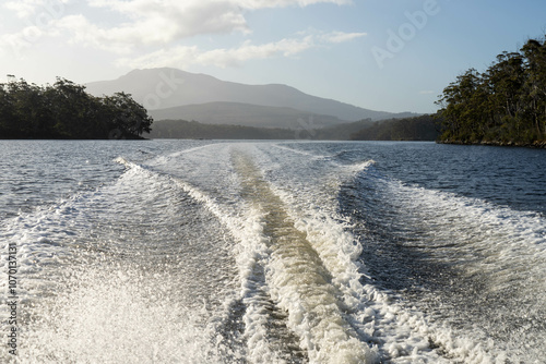 Obraz na plátně tinny dinghy boat on the water making a wake behind a boat making waves on a river in a national park in australia
