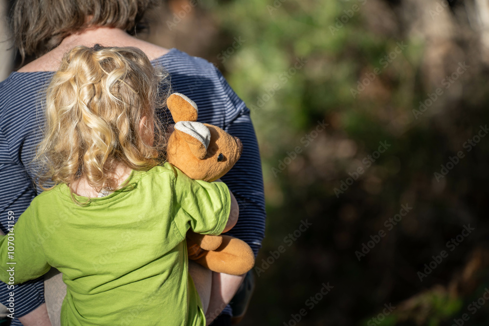Naklejka premium family with a toddler and children walking in nature exploring and learning, hiking in the trees and gardens. self playing