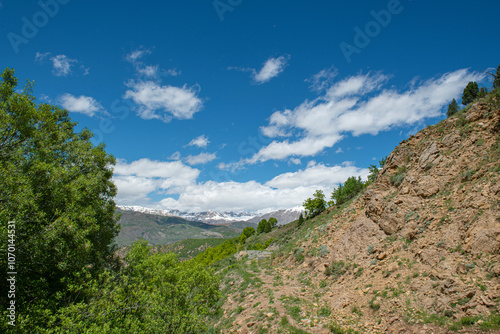 Green plains, snowy mountains. Blue sky and snowy mountains. Snowy mountains of Tunceli. Pülümür Valley, Buyer Mountain, Sarıgül Plateau, Buyer Waterfall.Munzur, Tunceli, Türkiye. 