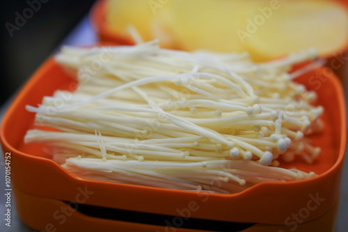 fresh enoki mushroom or golden needle mushrooms on plate in restaurant photo