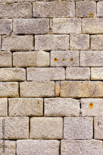 wall of granite ashlars in a Roman-period construction, textured background for archeology or architecture concept