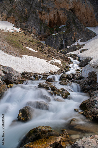 Long exposure river, stream. Glacial valleys and streams. Blue sky and snowy mountains. Snowy mountains of Tunceli. Pülümür Valley, Buyer Mountain, Sarıgül Plateau, Buyer Waterfall. Türkiye. photo