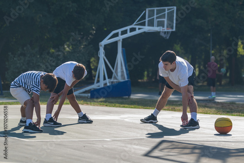 Boys stretches with a coach during basketball training, focusing on flexibility and sports fundamentals. Active coaching and essential warm up for youth basketball players.