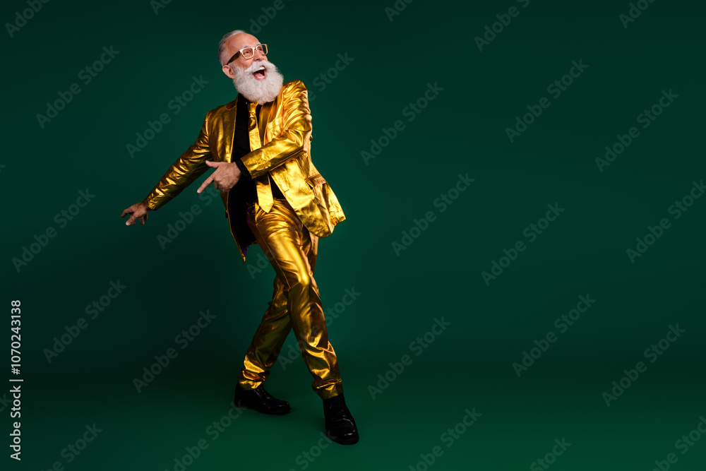Fototapeta premium Elegant senior man moves against a vibrant green backdrop, embodying retro glamour, perfect for Christmas and New Year parties.