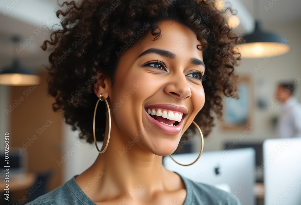Young woman with curly hair smiles joyfully in a modern office environment during daylight hours Young woman with curly hair smiles joyfully in a modern office environment during daylight hours