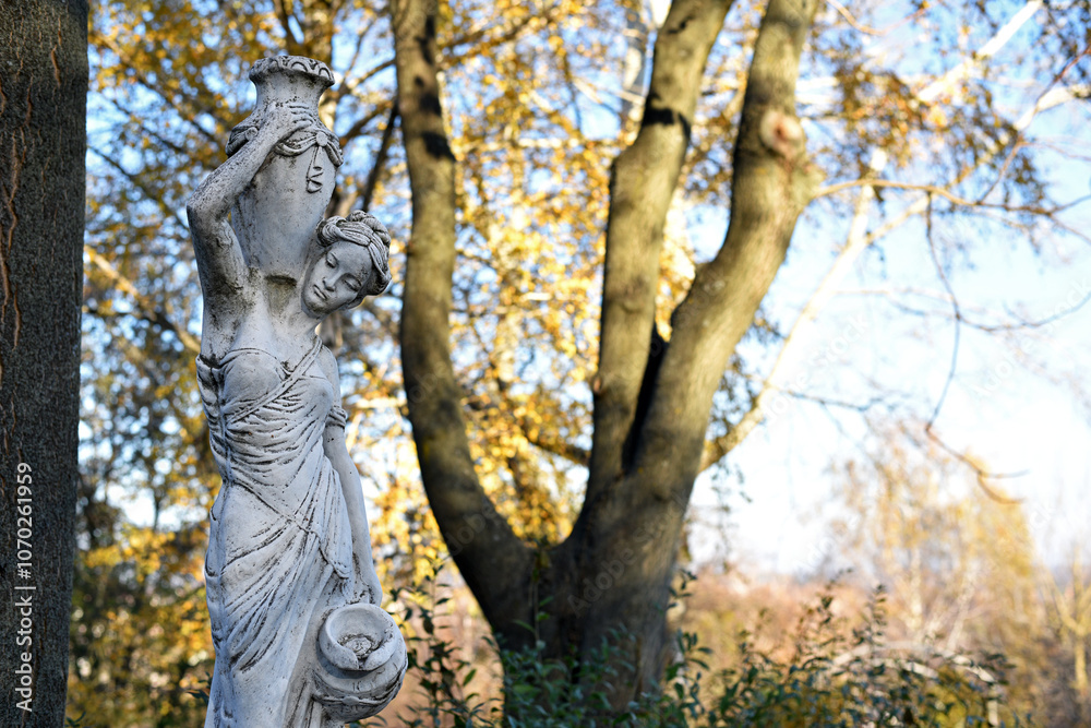 sculpture of a girl in the autumn park. An old statue in a park of a sensual semi-nude Greek or Italian Renaissance woman with a vase in a city park. sunny day in the spring garden. close-up sculpture of a girl in the autumn park. An old statue in a park of a sensual semi-nude Greek or Italian Renaissance woman with a vase in a city park. sunny day in the spring garden. close-up