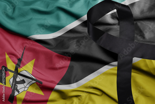 waving national flag of mozambique with black mourning ribbon .tragedy concept