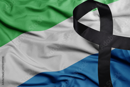 waving national flag of sierra leone with black mourning ribbon .tragedy concept