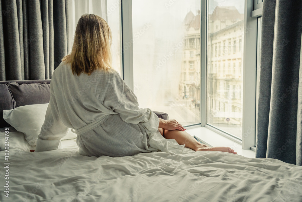 Woman in white bathrobe lying on sofa and relaxing at hotel room. Woman in white bathrobe lying on sofa and relaxing at hotel room.