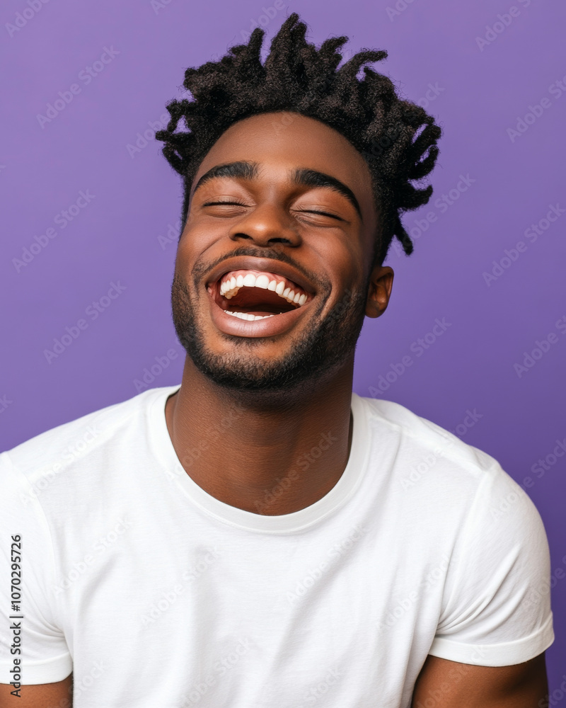A young man laughing joyfully, dressed casually, set against a pastel purple background. A young man laughing joyfully, dressed casually, set against a pastel purple background.