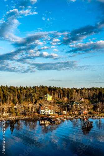Canvas Print Small idyllic port in the Swedish archipelago outside of Stockholm with beautiful reflection lighted with sunspot at autumn evening