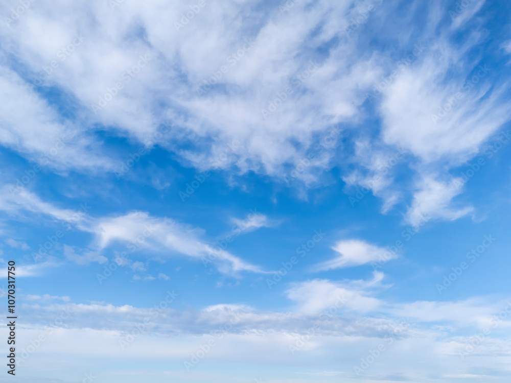 Naklejka premium A beautiful view of a clear sky with fluffy clouds showcasing the tranquility and beauty of nature