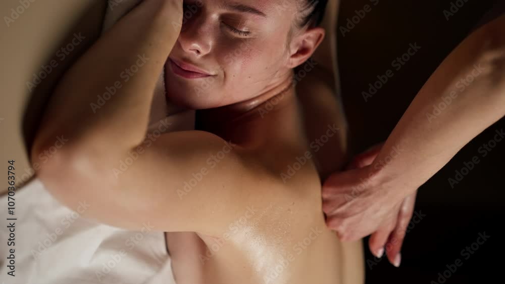 vertical video close up in massage parlor on a massage table a girl with a naked back preliminary warming up of the back with oil hands of a massage therapist vertical video close up in massage parlor on a massage table a girl with a naked back preliminary warming up of the back with oil hands of a massage therapist