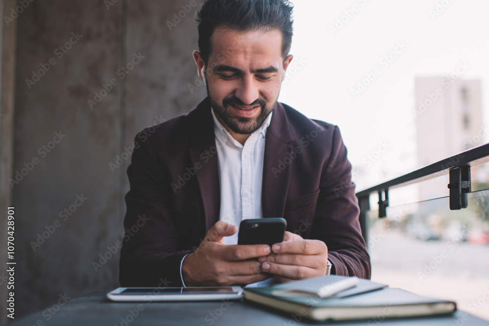 caucasian man in formal wear on coffee break sending text messages online enjoying radio via wireless bluetooth accessory, smiling successful male manager read news and listen music on cellphone caucasian man in formal wear on coffee break sending text messages online enjoying radio via wireless bluetooth accessory, smiling successful male manager read news and listen music on cellphone