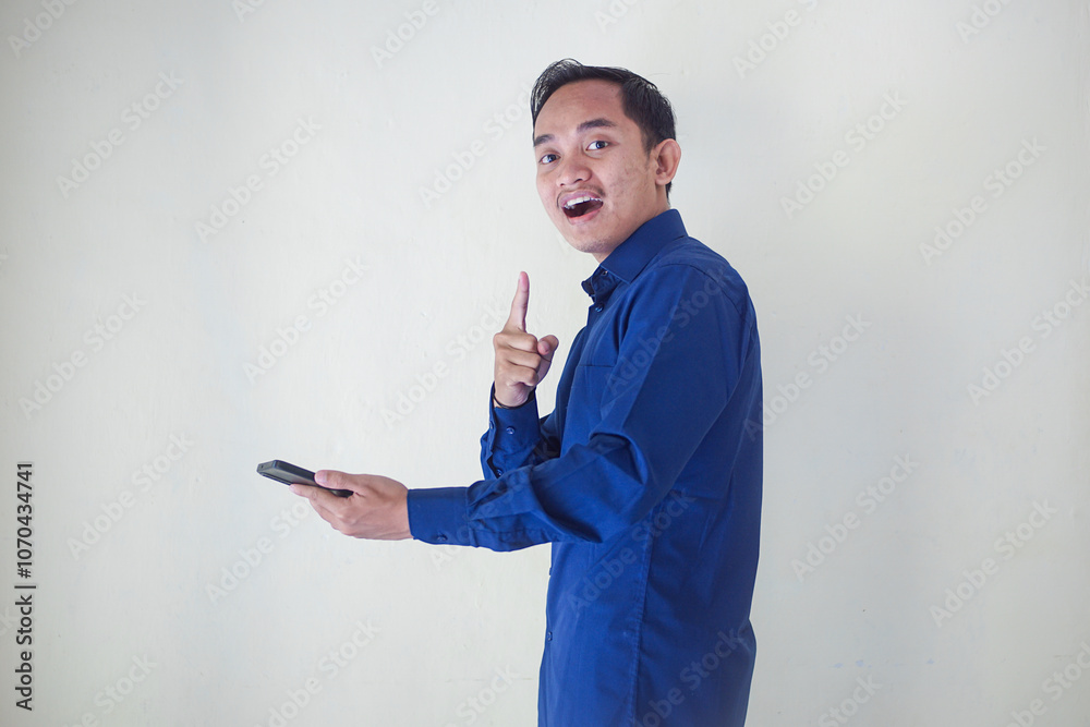 Excited young man holding a smartphone and making an 'OK' gesture, symbolizing positive communication, satisfaction, or success on white background. Perfect for communication concepts. Excited young man holding a smartphone and making an 'OK' gesture, symbolizing positive communication, satisfaction, or success on white background. Perfect for communication concepts.