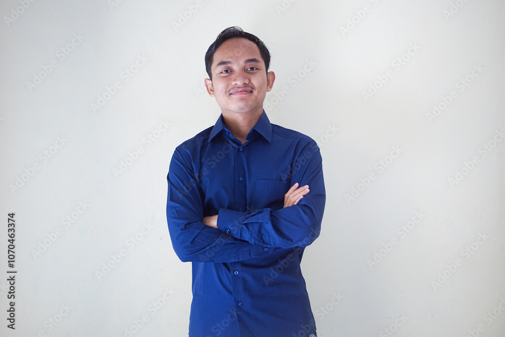 Cheerful young asian man in blue shirt pointing directly at camera and up, expressing joy and positivity on plain background, ideal for motivational and promotional content on white background Cheerful young asian man in blue shirt pointing directly at camera and up, expressing joy and positivity on plain background, ideal for motivational and promotional content on white background