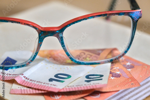 Blue and orange glasses on ten-euro bills.