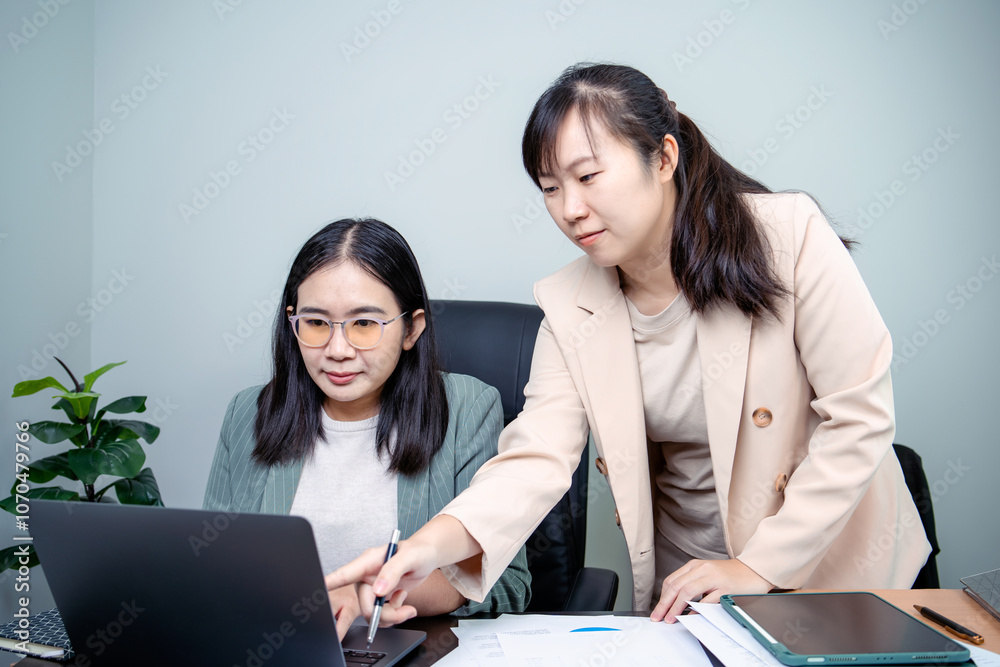 Two female employees, we are discussing work together Two female employees, we are discussing work together